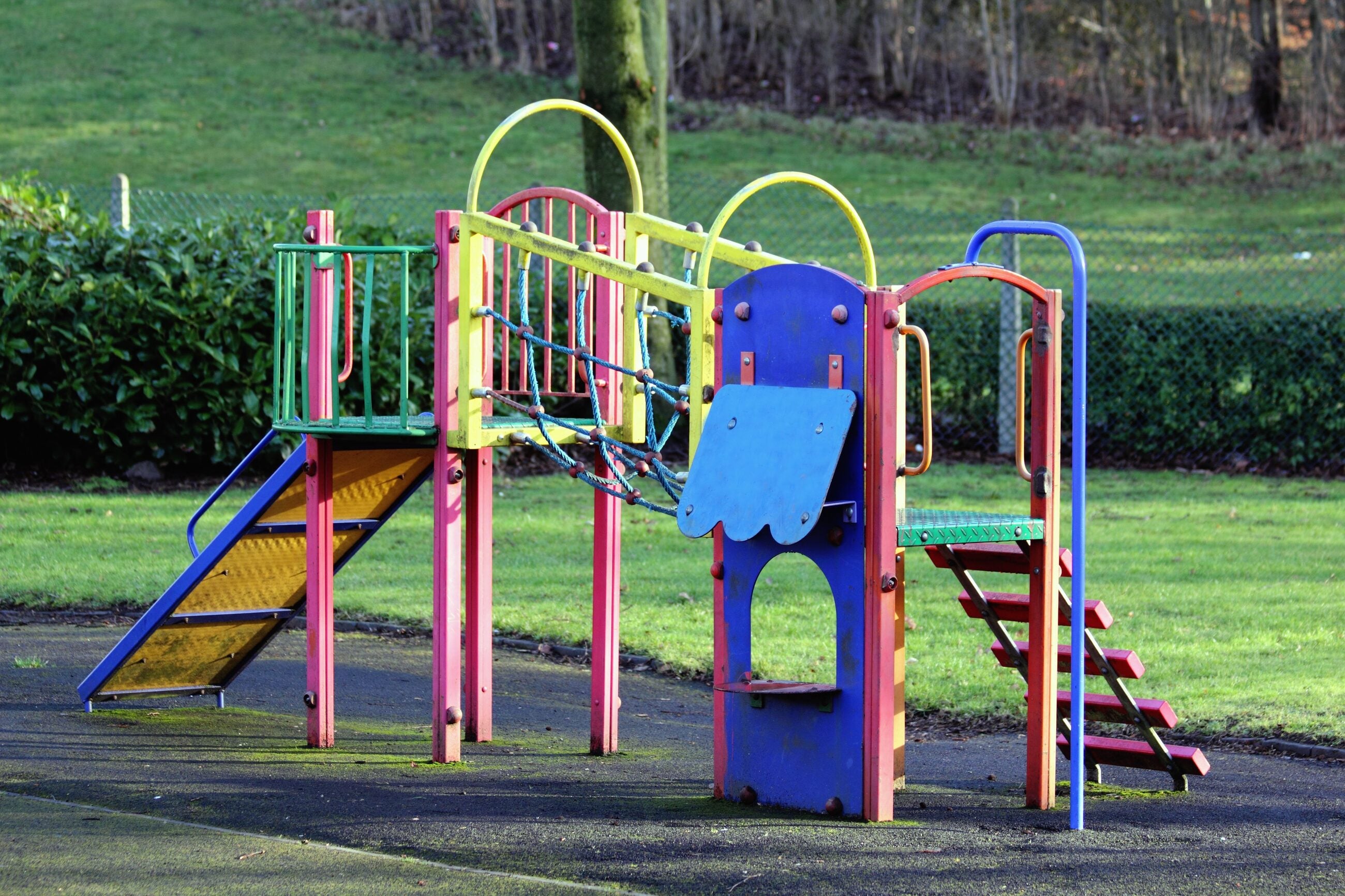 Volunteers maintaining a community church playground with loose-fill surfacing